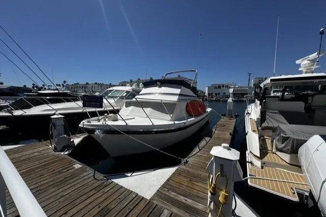 Slide: The Image of 1972 Luhrs 32 Convertible boat docked at marina under clear blue sky. - 1