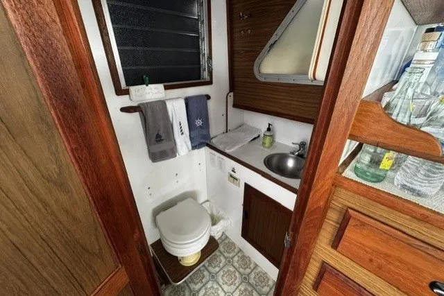 Slide: The Image of 1972 Luhrs 32 Convertible boat bathroom with wooden accents and compact sink area. - 13