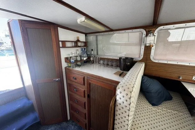 Slide: The Image of 1972 Luhrs 32 Convertible cabin interior with wooden cabinetry and seating area. - 7