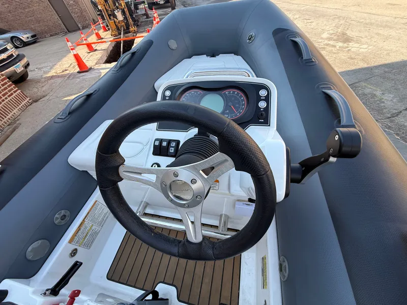 Slide: The Image of The image shows the cockpit of a 2022 Williams Jet Tenders Sportjet 345 with steering wheel and dashboard. - 2