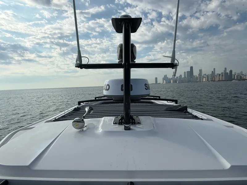Slide: The Image of The 2023 Axopar Brabus 37 XC Cross Cabin on calm waters with a city skyline in the background. - 37