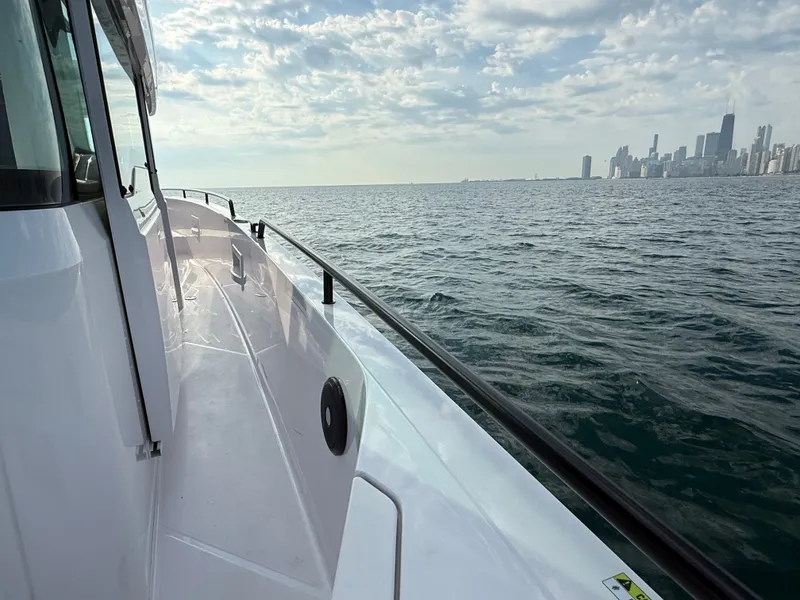 Slide: The Image of Axopar Brabus 37 XC Cross Cabin 2023 on the water with city skyline in the background. - 13