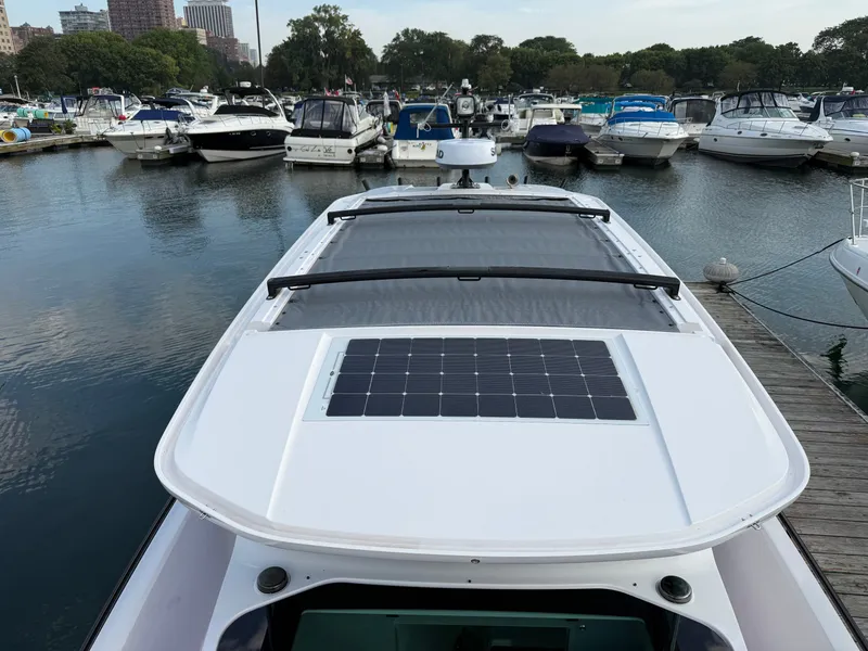 Slide: The Image of The 2023 Axopar Brabus 37 XC Cross Cabin is docked in a marina, surrounded by other boats. - 34