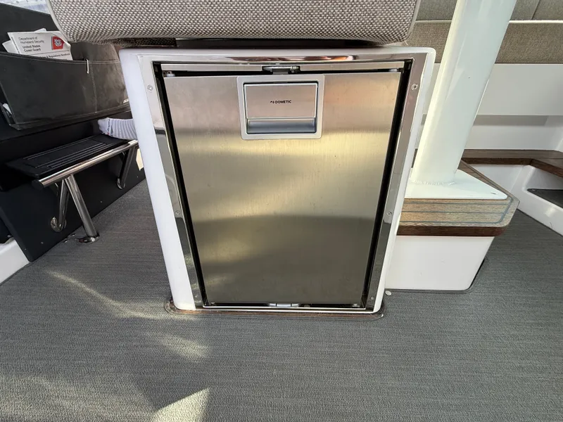 Slide: The Image of A compact refrigerator in a modern boat cabin with gray carpet flooring. - 40