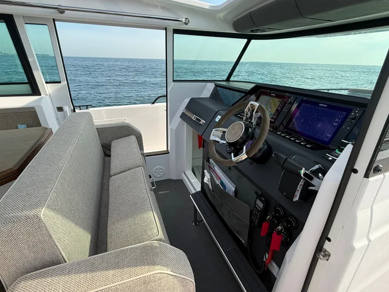 Slide: The Image of The image shows the cockpit of a 2023 Axopar Brabus 37 XC Cross Cabin with gray seating and modern electronics. - 24
