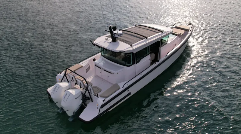 Slide: The Image of Axopar Brabus 37 XC Cross Cabin 2023 on calm water, featuring twin outboard engines. - 5
