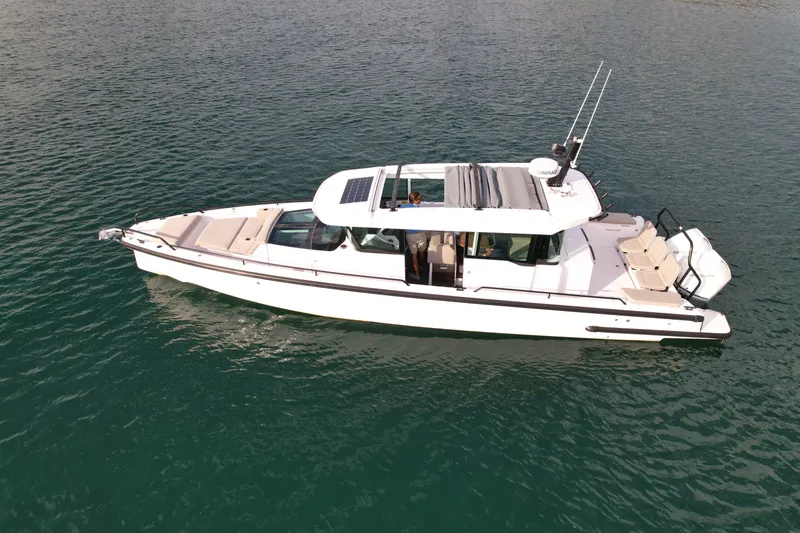 Slide: The Image of A 2023 Axopar Brabus 37 XC Cross Cabin on calm water. It features a modern design with an enclosed cabin area. - 1
