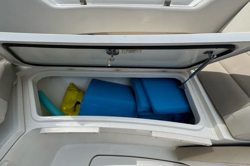 Slide: The Image of Open storage compartment on 2021 Boston Whaler 320 Vantage boat with blue and yellow gear. - 94