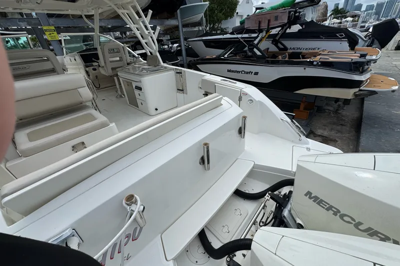 Slide: The Image of 2021 Boston Whaler 320 Vantage boat interior with Mercury engines, docked alongside other boats. - 27