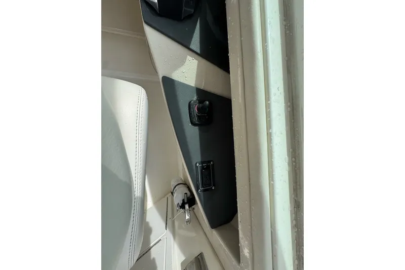 Slide: The Image of Interior detail of a 2021 Boston Whaler 320 Vantage boat, featuring control panel and seating. - 61