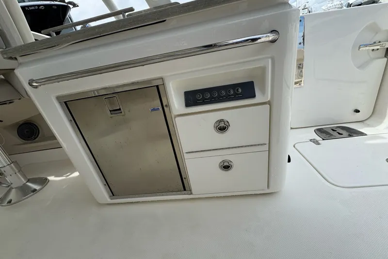 Slide: The Image of 2021 Boston Whaler 320 Vantage boat interior with storage compartments and control panel. - 47