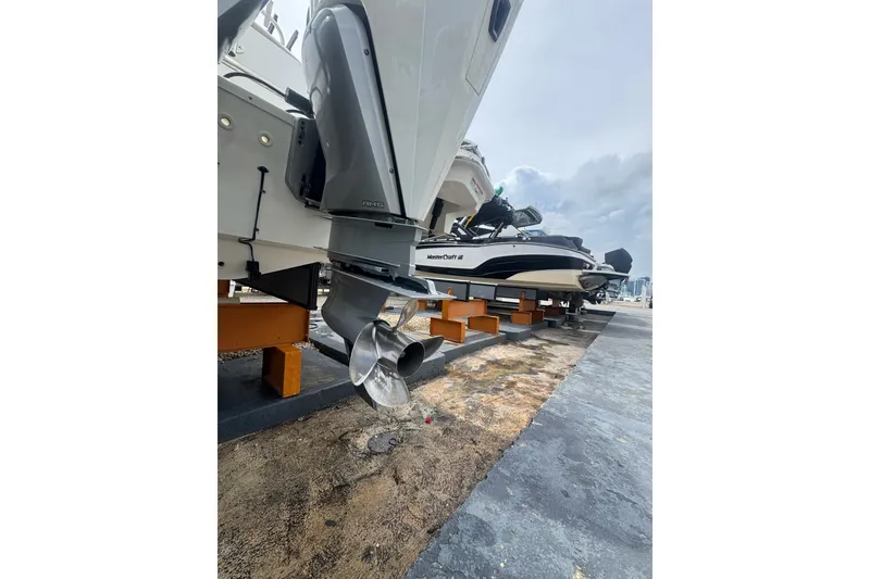 Slide: The Image of 2021 Boston Whaler 320 Vantage boat on dry dock, showcasing outboard motor and propeller. - 17