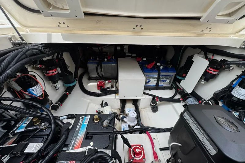 Slide: The Image of Engine compartment of a 2021 Boston Whaler 320 Vantage, showcasing batteries and wiring. - 37
