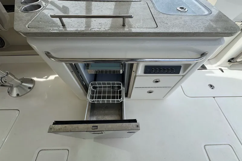 Slide: The Image of 2021 Boston Whaler 320 Vantage boat galley with open fridge and storage drawers. - 50