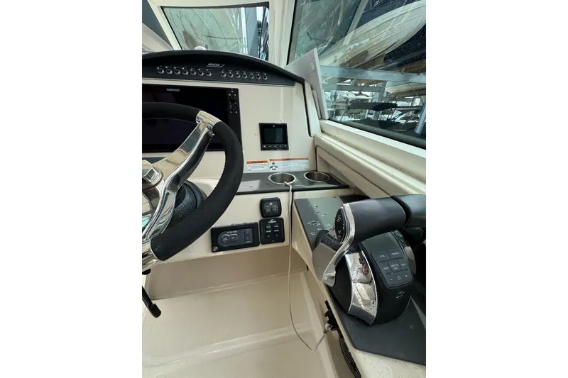 Slide: The Image of 2021 Boston Whaler 320 Vantage helm with steering wheel and control panel. - 62