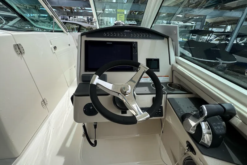 Slide: The Image of Cockpit of 2021 Boston Whaler 320 Vantage with steering wheel and control panel. - 59