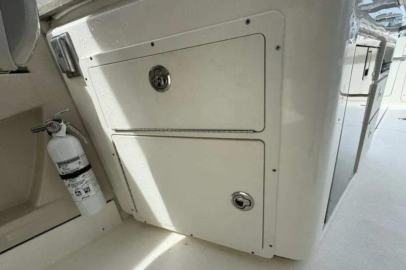 Slide: The Image of 2021 Boston Whaler 320 Vantage interior with storage compartment and fire extinguisher. - 52