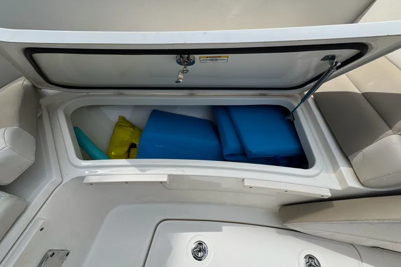 Slide: The Image of Storage compartment on a 2021 Boston Whaler 320 Vantage, containing blue and yellow gear. - 93