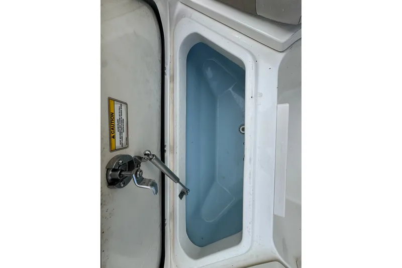 Slide: The Image of Livewell compartment on a 2021 Boston Whaler 320 Vantage boat, featuring a caution label. - 91