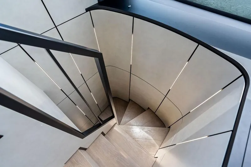 Slide: The Image of Modern spiral staircase inside 2025 Pershing GTX 80 yacht, featuring sleek design and ambient lighting. - 70