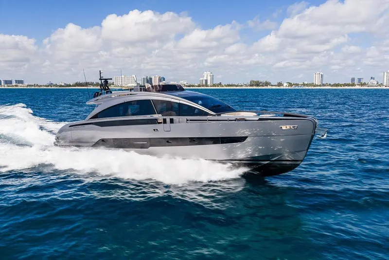 The Image of 2025 Pershing GTX 80 yacht cruising on blue ocean near city skyline. - 0