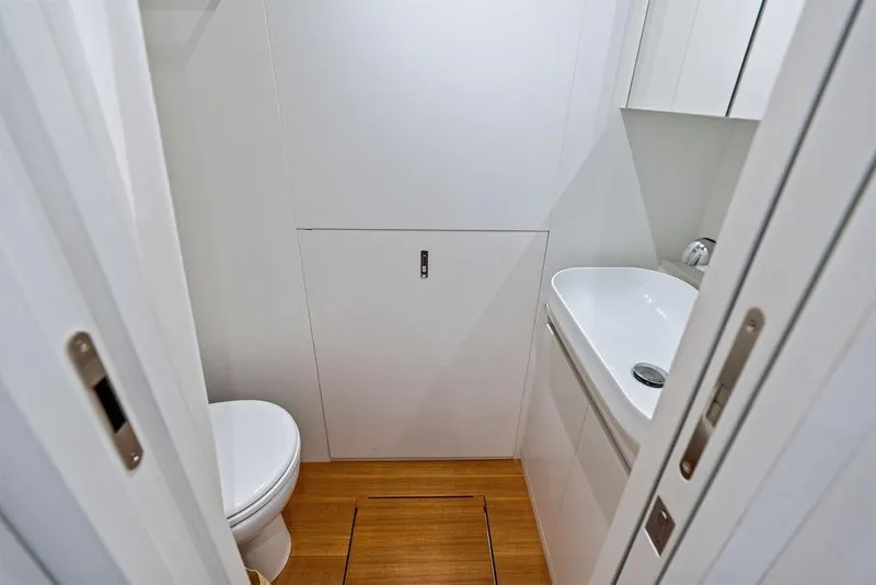 Slide: The Image of Compact bathroom interior on 2025 Pershing GTX 80 yacht, featuring modern fixtures and wooden flooring. - 91