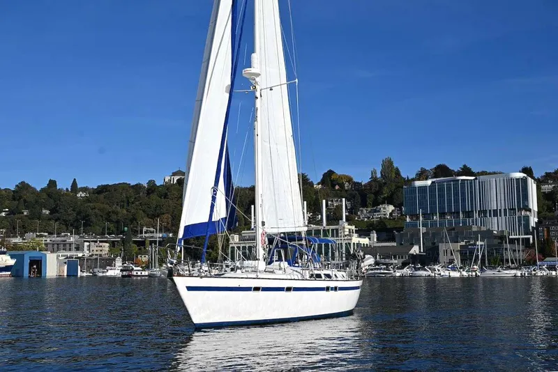Slide: The Image of 1989 Ta Shing Yachts Taswell 43 sailboat on calm water near urban marina. - 4