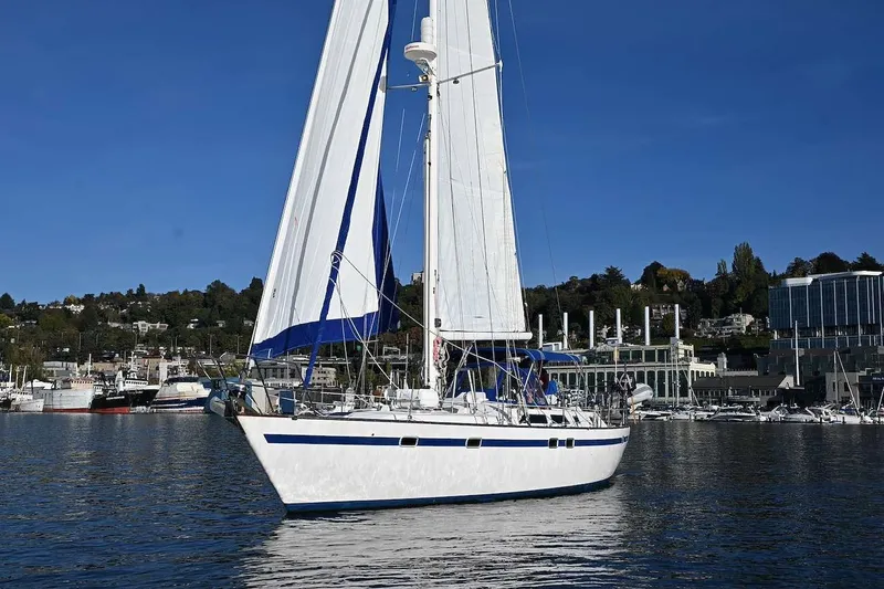 Slide: The Image of Sailing yacht Taswell 43 by Ta Shing Yachts, 1989, on calm waters with cityscape backdrop. - 3