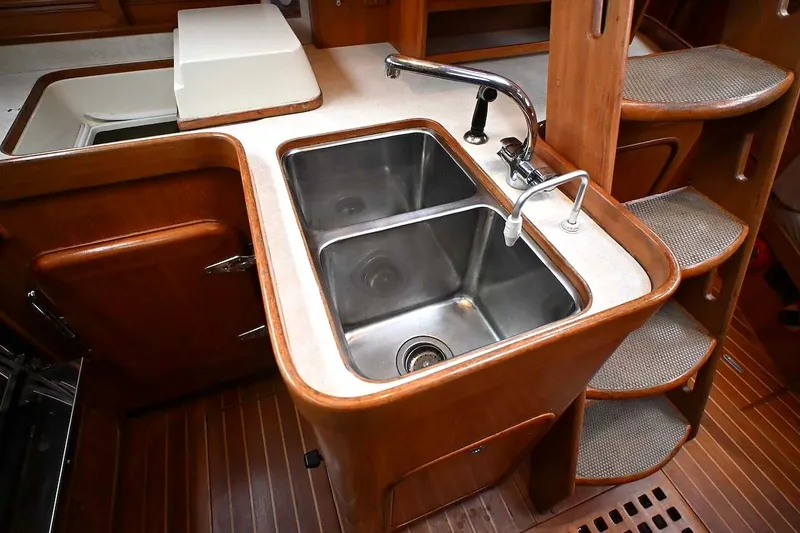 Slide: The Image of Galley sink area in 1989 Ta Shing Yachts Taswell 43, featuring wooden cabinetry and steps. - 56
