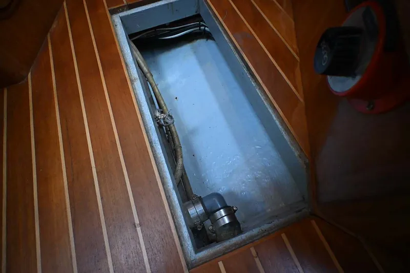 Slide: The Image of Open hatch on 1989 Ta Shing Yachts Taswell 43 wooden floor, revealing interior components. - 87