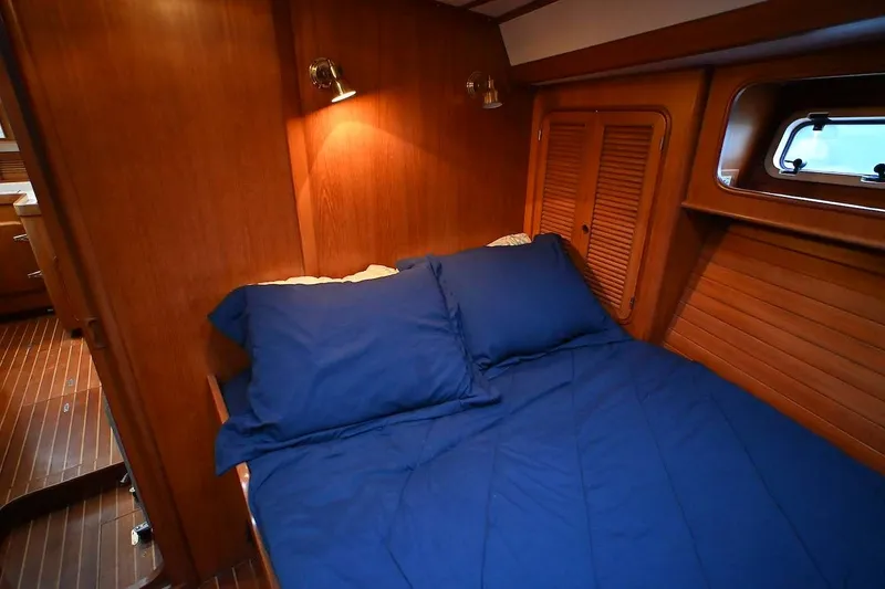 Slide: The Image of Cozy cabin interior of 1989 Ta Shing Yachts Taswell 43 with blue bedding and wooden paneling. - 66