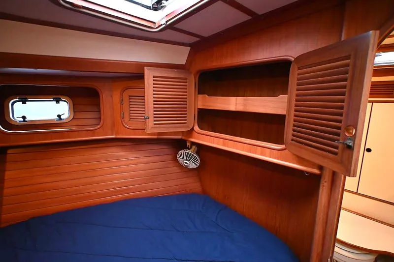 Slide: The Image of Interior cabin of 1989 Ta Shing Yachts Taswell 43, featuring wooden paneling and open storage. - 65