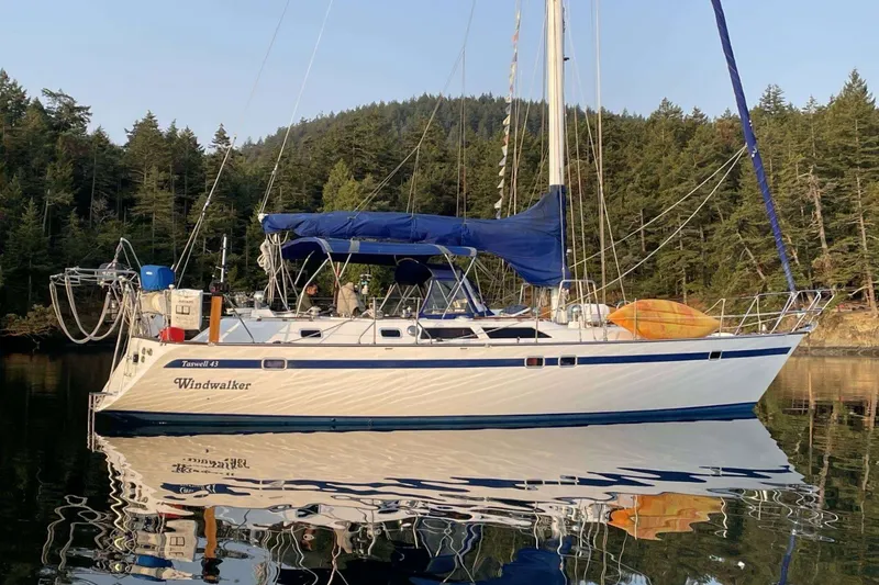 Slide: The Image of 1989 Ta Shing Yachts Taswell 43 sailboat anchored on calm water, surrounded by forest. - 8