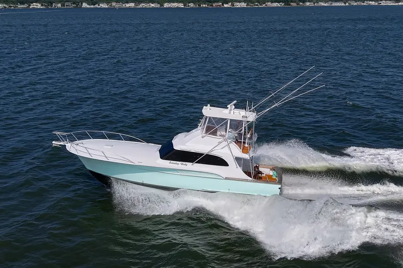 Slide: The Image of 1986 Buddy Davis 47 Convertible yacht cruising on open water. - 59