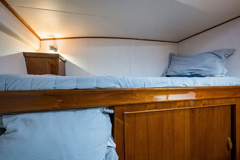 Slide: The Image of Cozy cabin interior of 1986 Buddy Davis 47 Convertible yacht with wooden finish and bedding. - 43