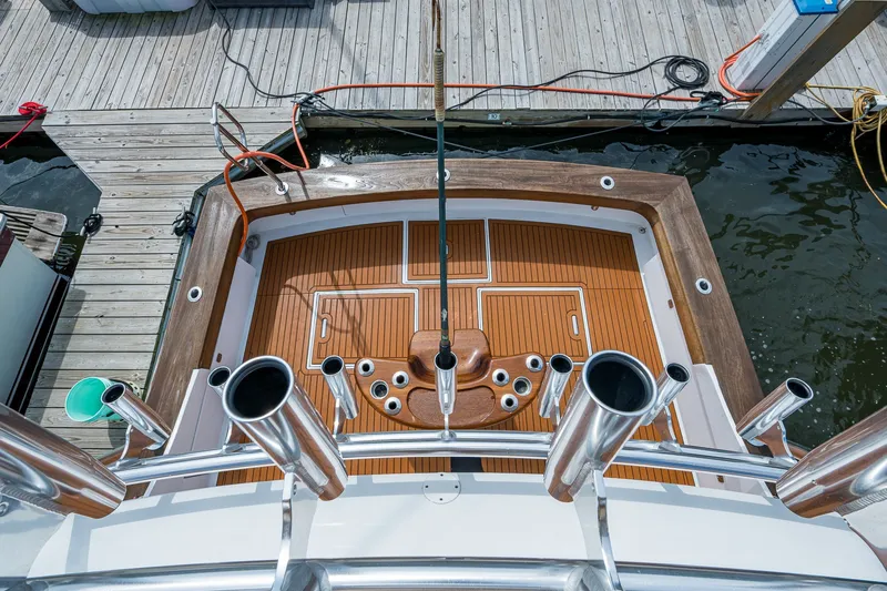 Slide: The Image of 1986 Buddy Davis 47 Convertible yacht deck with rod holders, docked at marina. - 14
