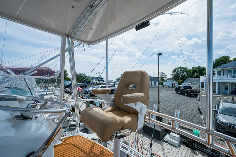 Slide: The Image of Captain's chair on 1986 Buddy Davis 47 Convertible yacht, docked with clear sky background. - 29