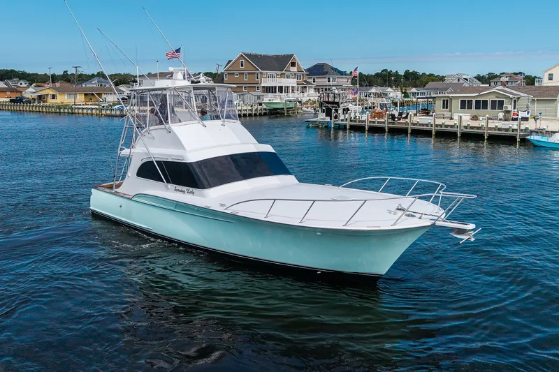 Slide: The Image of 1986 Buddy Davis 47 Convertible yacht cruising in a scenic harbor setting. - 53