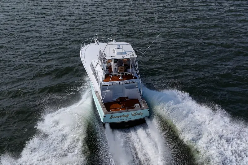 Slide: The Image of 1986 Buddy Davis 47 Convertible yacht cruising on open water, creating a wake. - 66