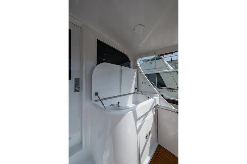 Slide: The Image of 1986 Buddy Davis 47 Convertible yacht interior with sink and storage area. - 13