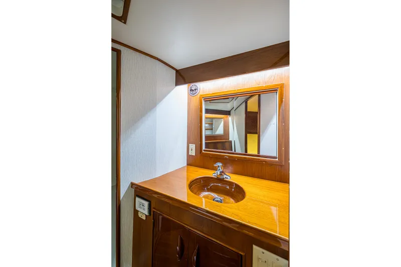 Slide: The Image of 1986 Buddy Davis 47 Convertible yacht bathroom with wooden vanity and mirror. - 33