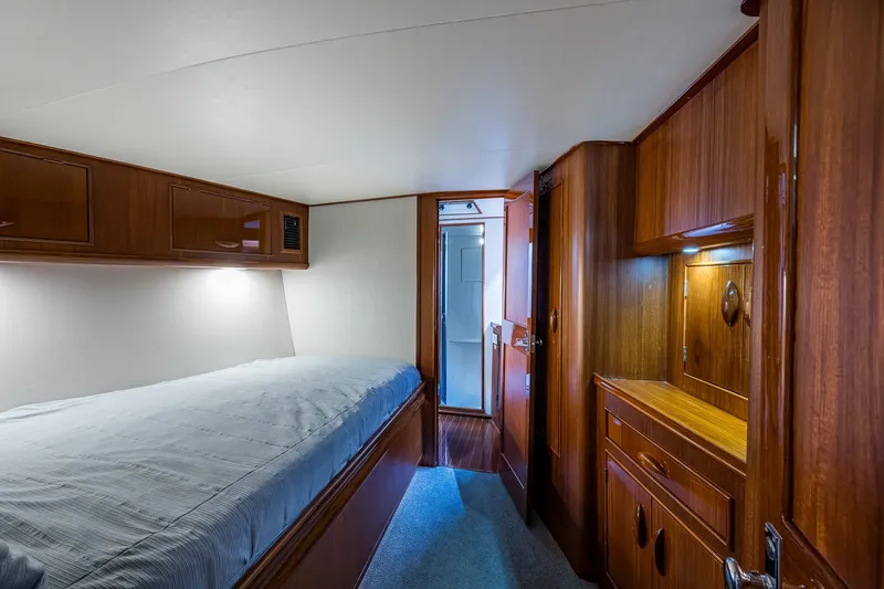 Slide: The Image of Interior cabin of 1986 Buddy Davis 47 Convertible yacht, featuring wood paneling and cozy bedding. - 37