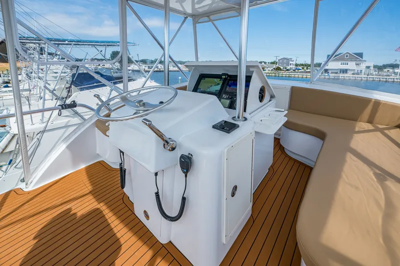 Slide: The Image of 1986 Buddy Davis 47 Convertible yacht helm with modern controls and seating, docked at marina. - 24
