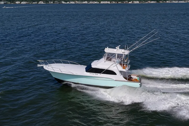 Slide: The Image of 1986 Buddy Davis 47 Convertible yacht cruising on open water, showcasing sleek design and performance. - 60