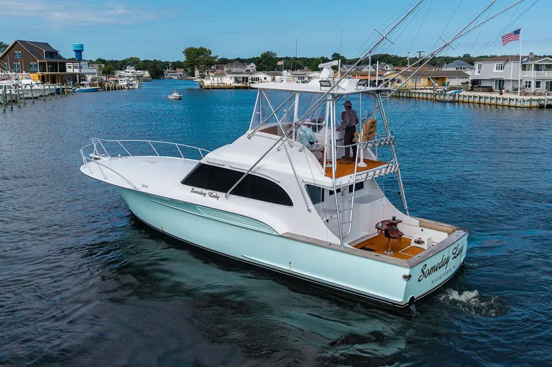 Slide: The Image of 1986 Buddy Davis 47 Convertible yacht cruising in a marina with people on deck. - 57