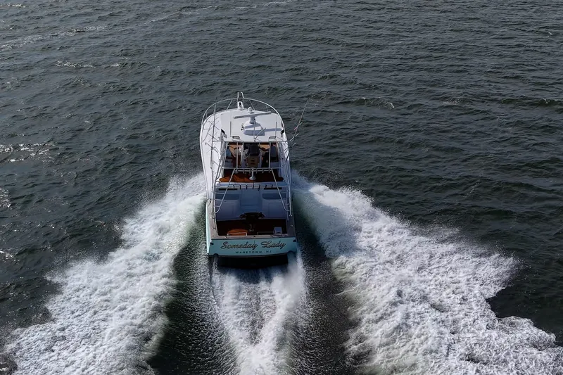 Slide: The Image of 1986 Buddy Davis 47 Convertible yacht cruising on open water, creating a wake. - 68