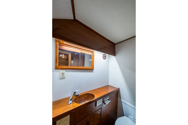 Slide: The Image of 1986 Buddy Davis 47 Convertible yacht bathroom with wooden vanity and mirror. - 38