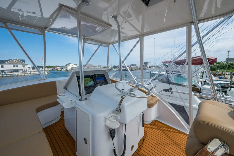 Slide: The Image of Interior view of 1986 Buddy Davis 47 Convertible yacht helm with waterfront background. - 27