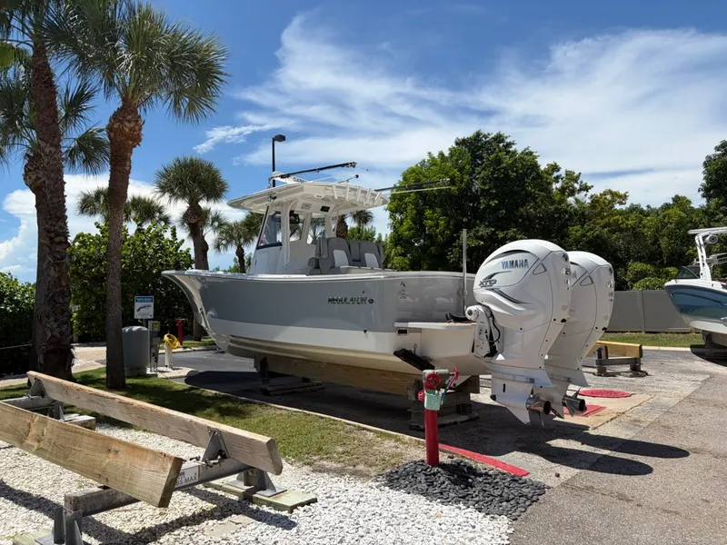 Slide: The Image of A 2022 Regulator 31 boat on a trailer, surrounded by palm trees. - 23