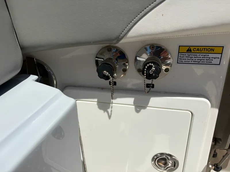 Slide: The Image of Two fuel caps with chains on a white boat, accompanied by a caution label. - 6